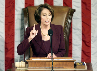 The speaker of the house openly addresses colleagues while wearing lipstick and pantyhose.